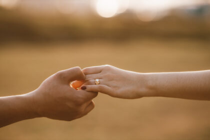 Verliebtes Paar hält Händchen mit Ringen als Symbol der Liebe