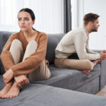 Paar sitzt schweigend nebeneinander nach einem Streit