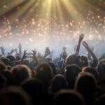 Bühnenlichter und jubelndes Publikum bei einem Stadionkonzert