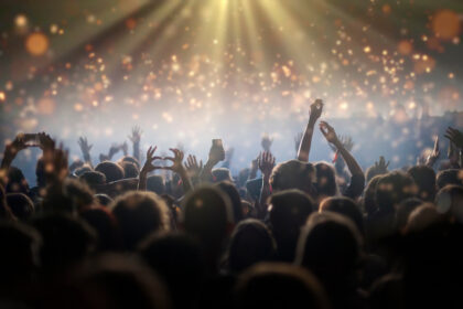 Bühnenlichter und jubelndes Publikum bei einem Stadionkonzert