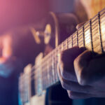Musiker spielt E-Gitarre bei einem Rockkonzert auf der Bühne