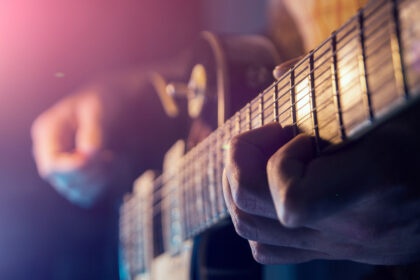 Musiker spielt E-Gitarre bei einem Rockkonzert auf der Bühne