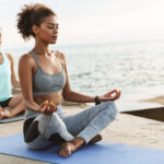 Zwei Frauen machen Yoga-Übungen auf Fitnessmatten